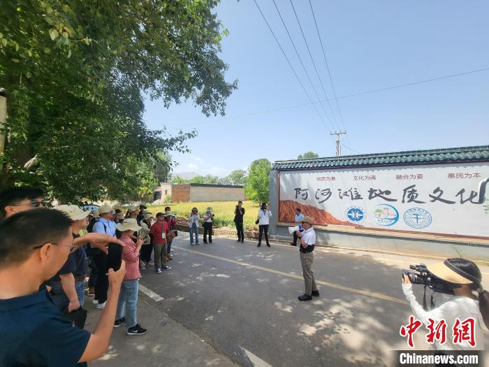 圖為中國地質(zhì)大學(北京)教授張緒教介紹村落情況。　胡友軍 攝