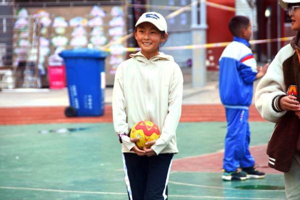 在高原上教孩子們打手球，“慢慢兒來(lái)，甭著急！”