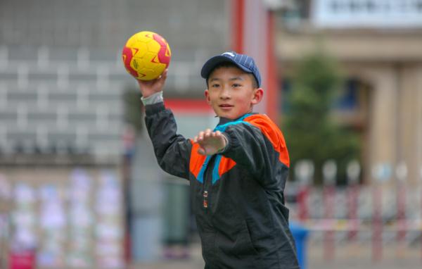 在高原上教孩子們打手球，“慢慢兒來(lái)，甭著急！”