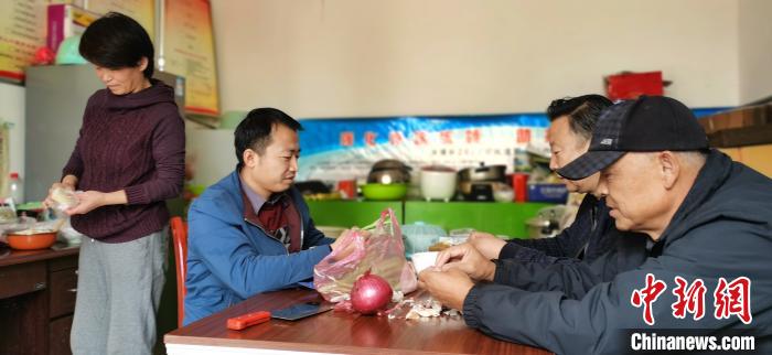 圖為扶貧路上“臨時一家人”準(zhǔn)備午餐?！∥航ㄜ?攝