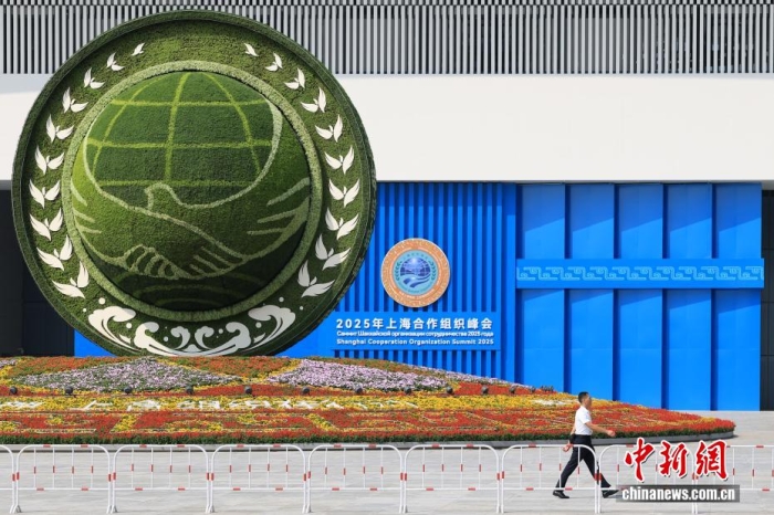 8月31日，天津，一名工作人員從2025年上海合作組織峰會主會場外的景觀花壇旁經(jīng)過。當(dāng)日，2025年上海合作組織峰會在天津舉行。<a target='_blank' href='/'><p  align=