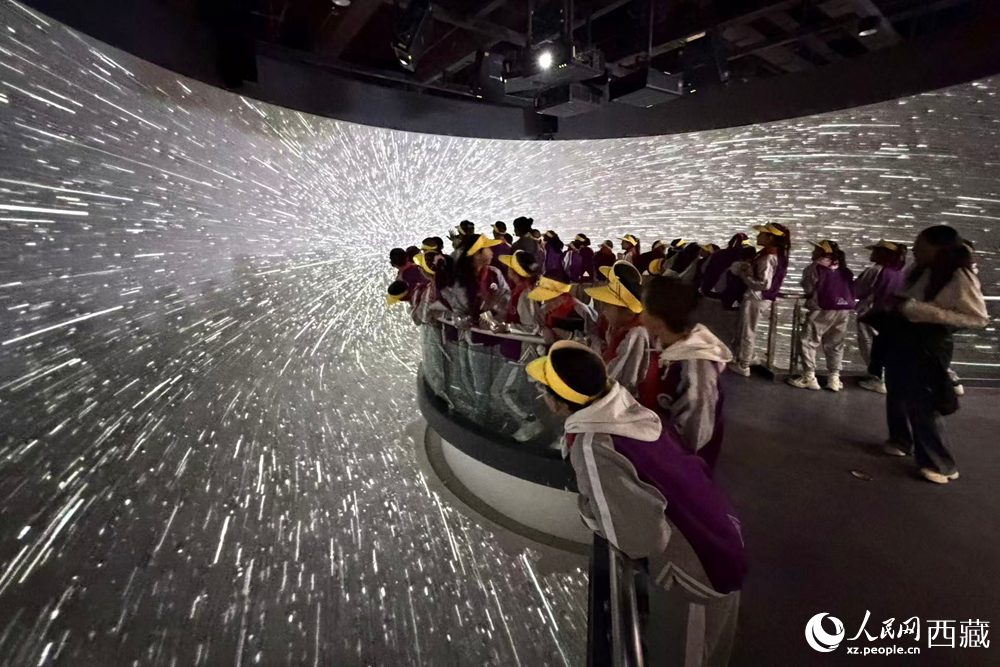 藏域星球天文體驗館中，小學生在沉浸式星空隧道里仰望璀璨星河，感受宇宙穿梭帶來的視覺震撼與科學魅力。人民網(wǎng)記者 次仁羅布攝