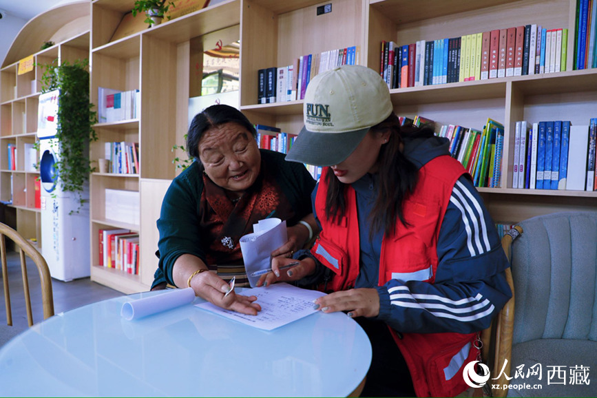 幸福社區(qū)的網(wǎng)格員協(xié)助老人填寫雙聯(lián)戶檔案表。人民網(wǎng)記者 次仁羅布攝