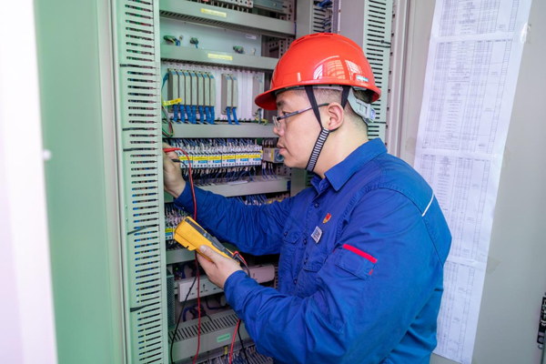 呂曉勇在保護(hù)盤柜前檢查二次回路接線情況。受訪者供圖