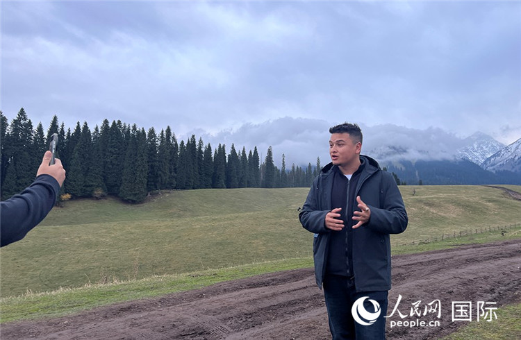 在庫(kù)爾德寧，吾買爾江被雪山美景震撼，即興錄制了短視頻作品。人民網(wǎng)記者曾書柔攝