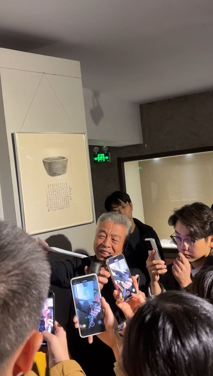 黑陶邢文化博物館館長邢葆東展示兩張相疊的A4紙，向記者解釋此為杯口的厚度。