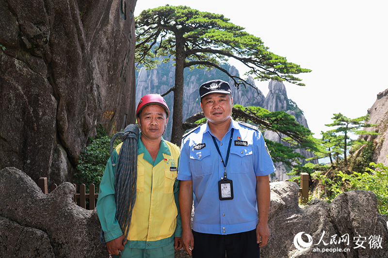 全國道德模范李培生（左）和胡曉春在迎客松前合影。人民網(wǎng)記者 張俊攝
