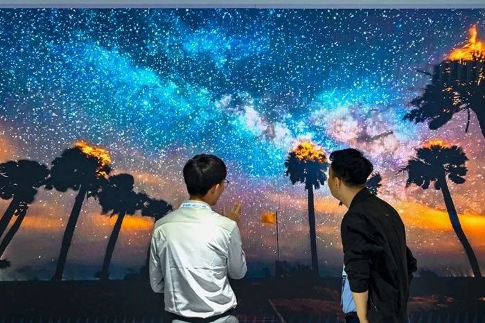 長(zhǎng)春光博會(huì)希達(dá)電子展區(qū)，一位工作人員正在給一位觀眾講解。（長(zhǎng)春新區(qū)供圖）