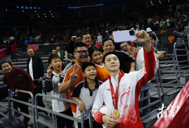 11月12日，十五運(yùn)會(huì)男籃成年組決賽，廣東隊(duì)獲得冠軍后，胡明軒與球迷們合影留念。張由瓊 攝