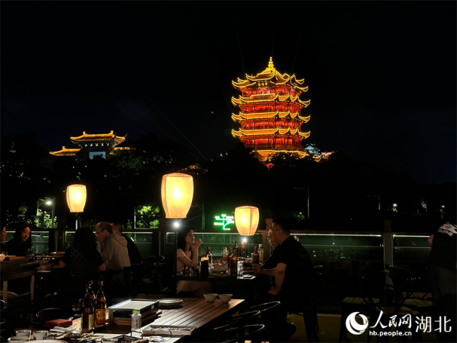游客登上天臺(tái)，賞美景、品美食，沉浸式飽覽黃鶴樓的璀璨夜景。人民網(wǎng) 彭昀迪攝