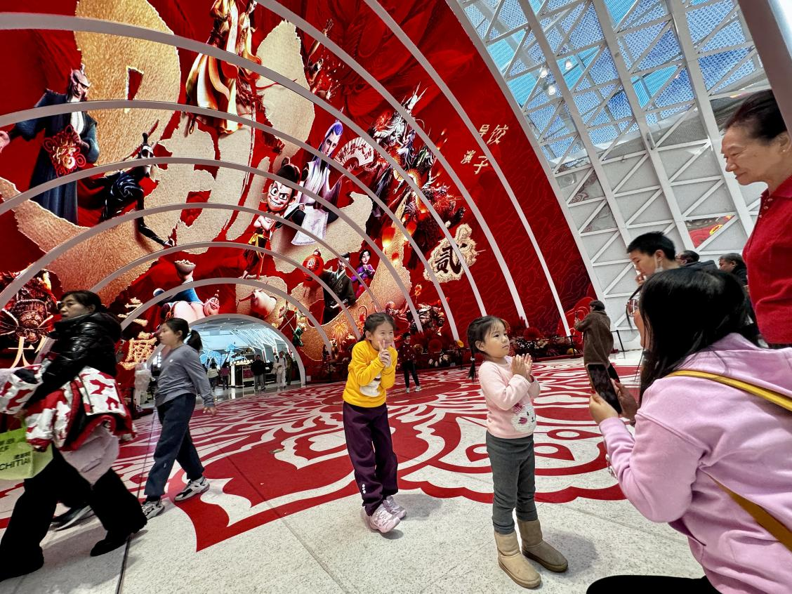 乙巳蛇年春節(jié)期間，影迷在《哪吒之魔童鬧?！肪薹?bào)前拍照打卡。