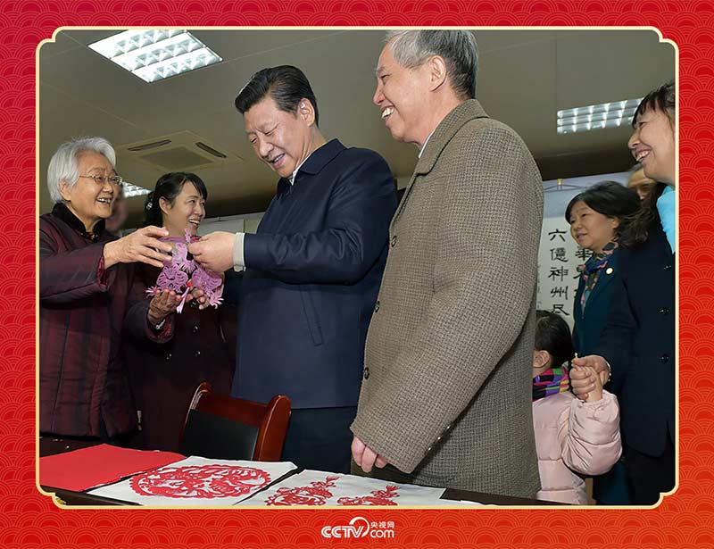 2015年2月15日，習(xí)近平在西安市雁塔區(qū)電子城街道二〇五所社區(qū)服務(wù)中心欣賞社區(qū)居民的剪紙作品。