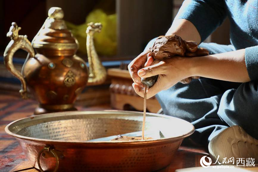 牛角鉆孔，將木泥擠出。人民網(wǎng)記者 次仁羅布攝