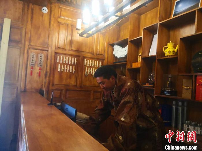 圖為桑杰才讓用電腦處理財務(wù)?！∈缝o靜 攝