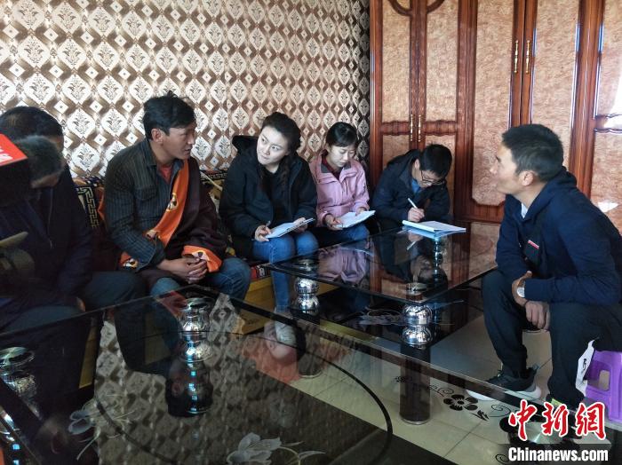 圖為調(diào)查組工作人員正在入戶調(diào)查?！∑钤鲚?攝