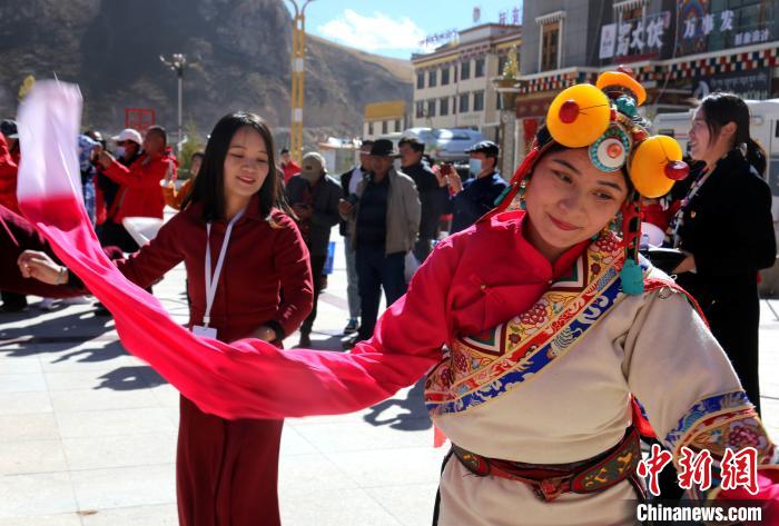 圖為中外記者向當(dāng)?shù)孛癖妼W(xué)習(xí)民族歌舞文化?！?zhí)砀?攝