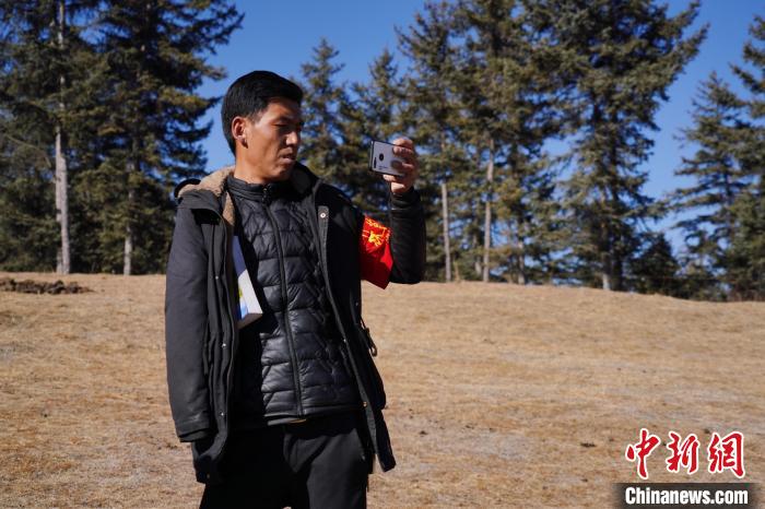 圖為桑杰加進(jìn)行巡查并拍照記錄?！●R銘言 攝