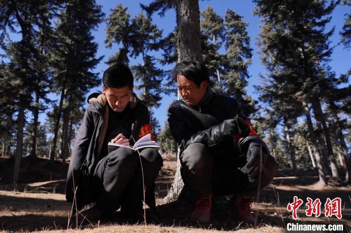 圖為桑杰加(左)和同事記錄巡查結(jié)果?！●R銘言 攝