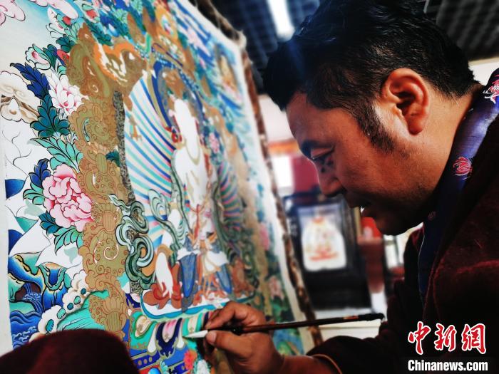 圖為久美尖措創(chuàng)作唐卡?！?zhí)砀?攝