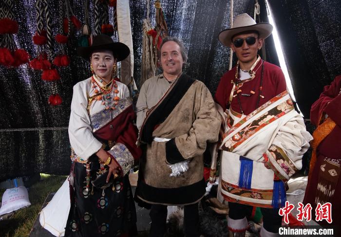 圖為一名外籍?dāng)z影師(中)身穿藏服和藏族民眾合影留念?！●R銘言 攝