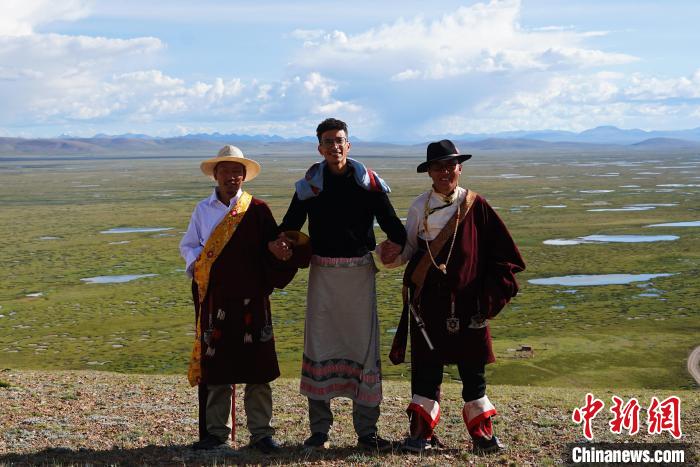 圖為一名留學(xué)生身穿自己國家的服飾和藏族民眾合影留念?！●R銘言 攝