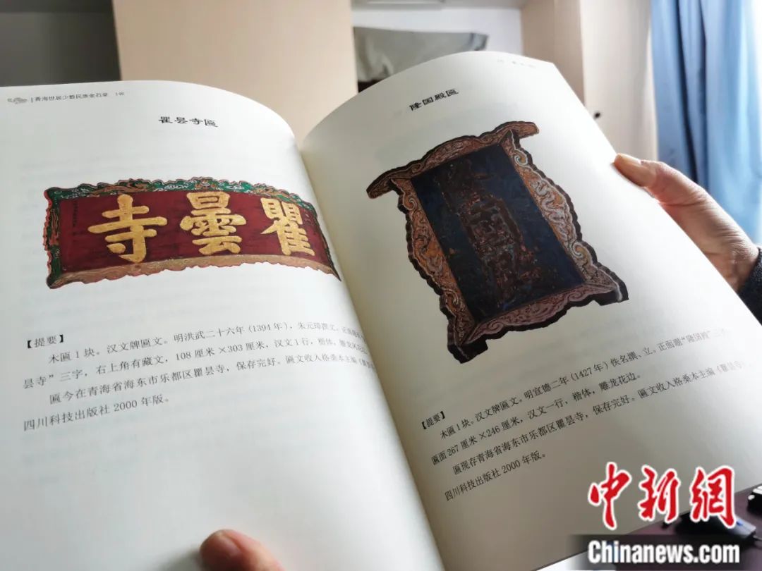 古籍保護人員展示介紹明代朱元璋撰寫的青海瞿曇寺匾(左)的出版書籍。張?zhí)砀?攝