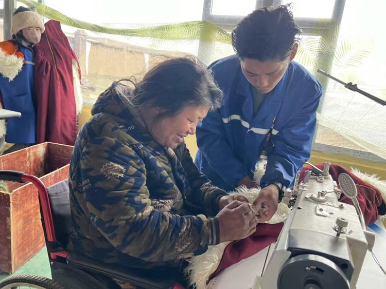 扎西奪爾登幫助殘疾員工裁剪。阿壩州文明辦供圖