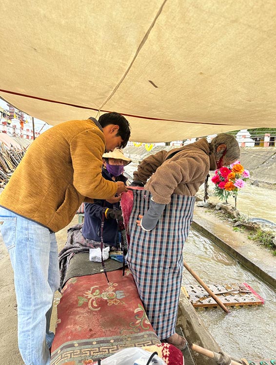 扎西奪爾登為路邊老人送去保暖圍腰。阿壩州文明辦供圖