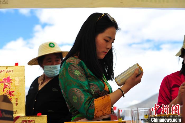 圖為拉薩市民在特色農(nóng)畜產(chǎn)品展示展銷會(huì)上選購商品?！垈?攝