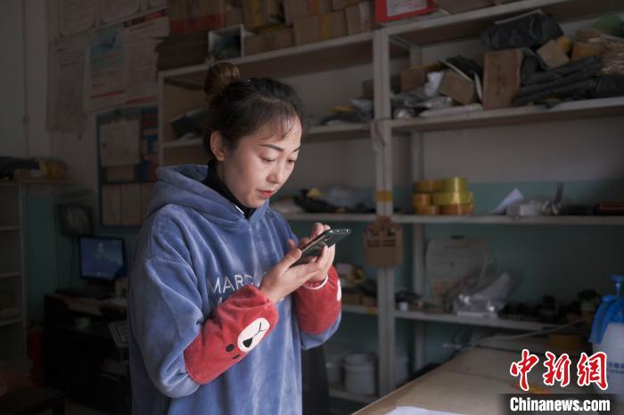 正在快遞站點(diǎn)內(nèi)忙碌的楊莉春?！『闻罾?攝