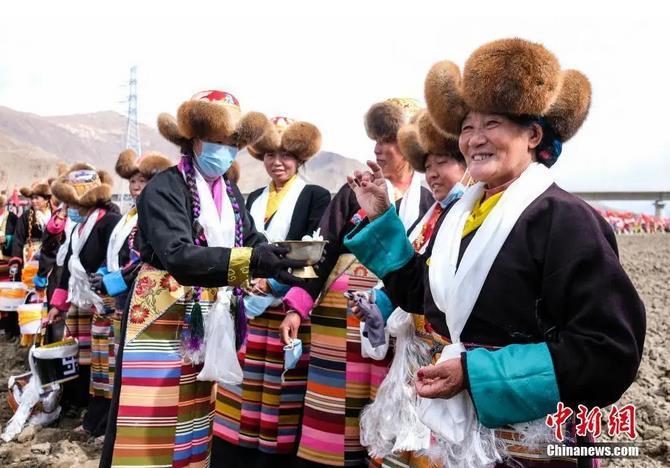資料圖：西藏自治區(qū)拉薩市曲水縣才納鄉(xiāng)協(xié)榮村參加春耕儀式的村民互敬青稞酒。按照傳統(tǒng)，當(dāng)?shù)卮迕裆碇?jié)日盛裝，舉行隆重的儀式，祈福一年的豐收。<a target='_blank' ><p  align=