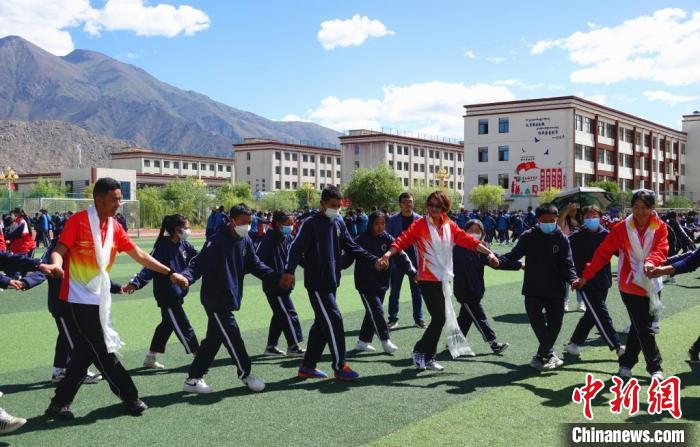 圖為世界冠軍與拉薩阿里地區(qū)高級(jí)中學(xué)學(xué)生一起跳鍋莊?！∪轿木?攝