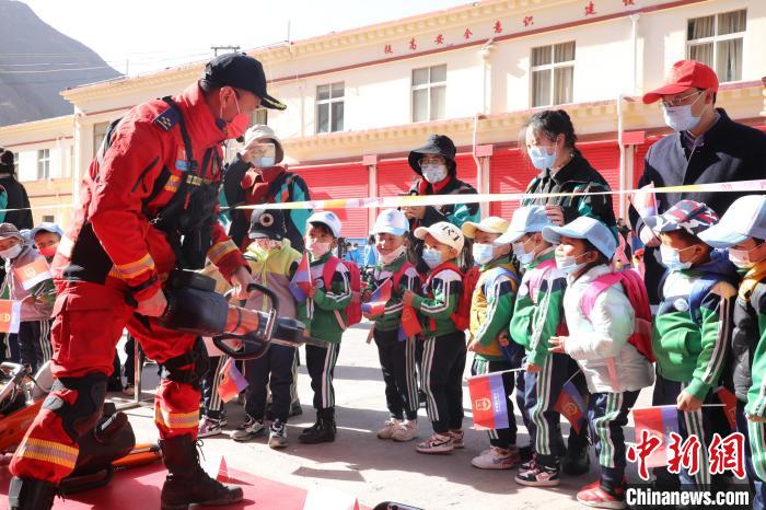 圖為消防指戰(zhàn)員為學(xué)生講解、演示先進(jìn)救援裝備?！≮w琳 攝