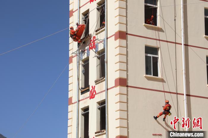 圖為消防指戰(zhàn)員進(jìn)行繩索救援演練。　朱科熹 攝