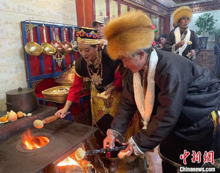 圖為人們?cè)诨鹕峡竟?jié)日美食“結(jié)達(dá)”?！∪轿木?攝