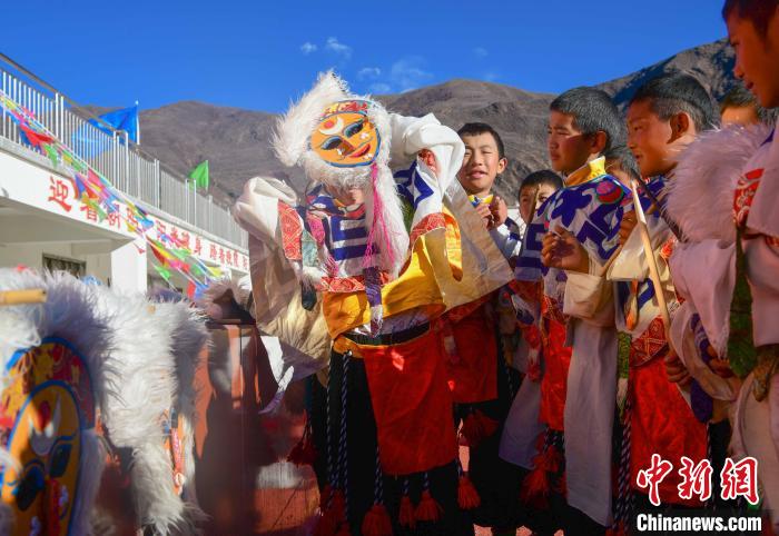圖為加查縣安繞鎮(zhèn)小學(xué)學(xué)生在試穿藏戲面具?！∝暩聛?lái)松 攝
