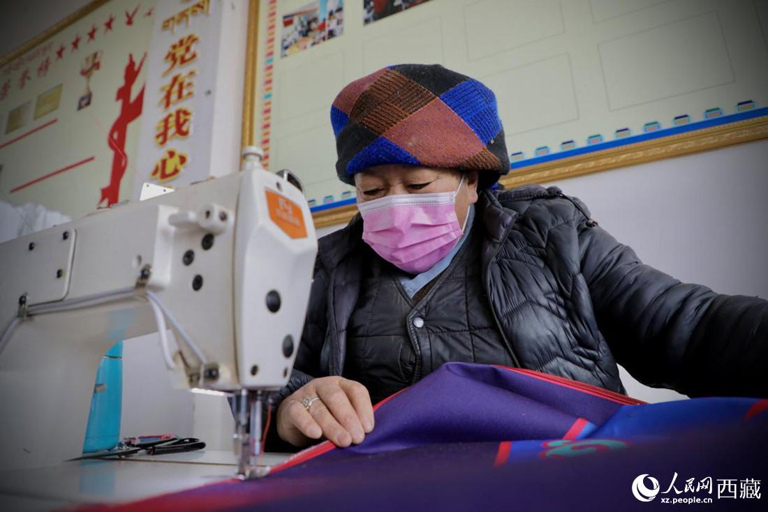 農(nóng)牧民專業(yè)合作社里的村民正在制作門簾。人民網(wǎng) 次仁羅布攝