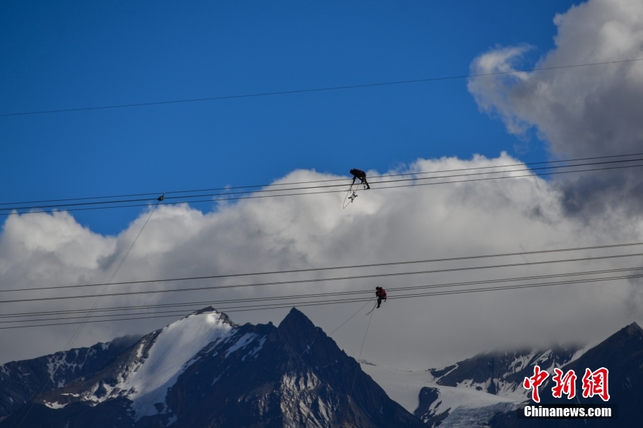 資料圖為2020年6月23日，西藏阿里聯(lián)網(wǎng)工程施工人員在日喀則希夏邦馬雪山附近進(jìn)行走線作業(yè)，安裝絕緣設(shè)備。 <a target='_blank' href='/'><p  align=
