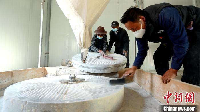 圖為合作社負(fù)責(zé)人完成糌粑加工后清掃水磨設(shè)施?！〖卫杩h融媒體中心供圖