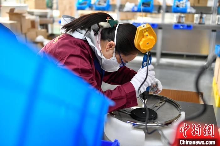 圖為工人正在組裝炊具。　貢嘎來松 攝