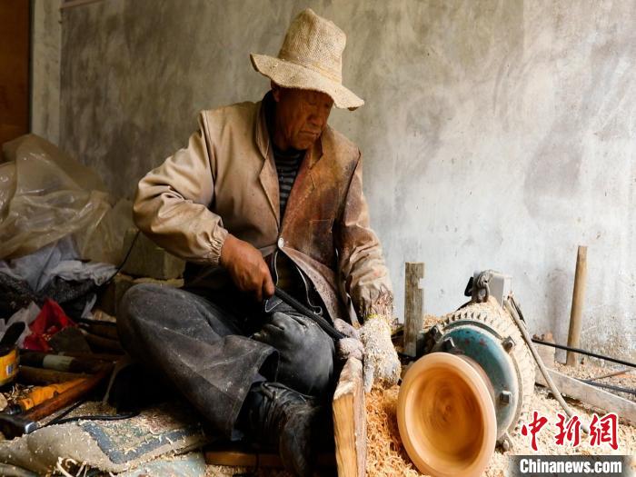 圖為手工藝人正在制作木碗?！?鄧海平 攝