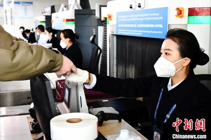 圖為機場工作人員為旅客辦理行李托運?！≈芎?攝