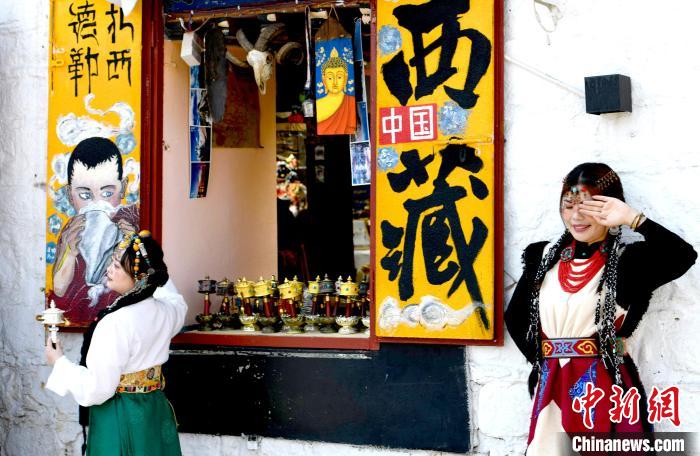 4月17日，游客身著藏式元素服裝在拉薩八廓街拍照留念?！±盍?攝
