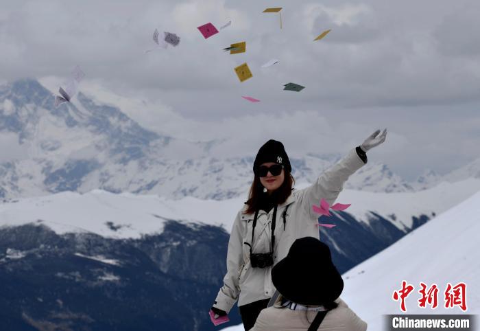 圖為5月14日，游客在西藏林芝色季拉山觀景臺拋灑“隆達”(風馬旗，藏族民眾的一種祈福方式)?！±盍?攝