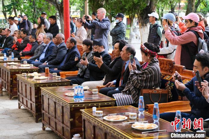 5月19日，中外嘉賓在羅布林卡和游客一起觀看藏戲?！〗w波 攝