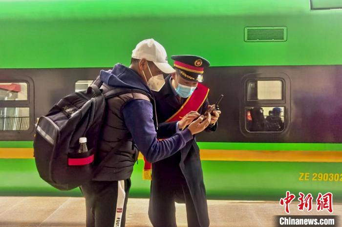 圖為日喀則火車站工作人員服務(wù)乘客?！《飞降?攝