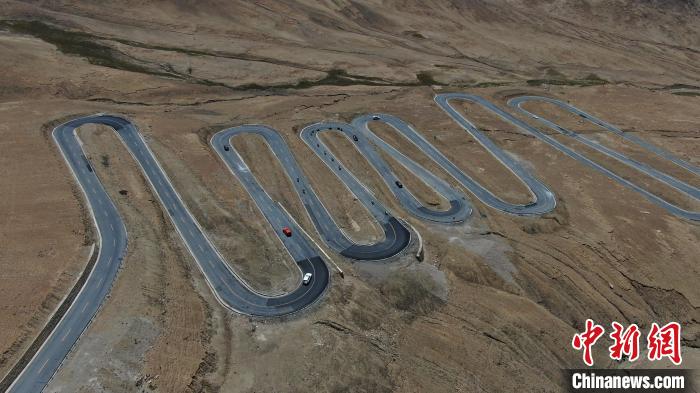 圖為騎手前往珠峰大本營(yíng)途經(jīng)108道拐?！∮文恋厍蚬﹫D