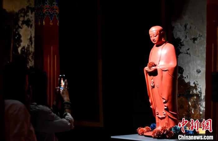 圖為觀眾正在欣賞展覽中的雕塑作品。