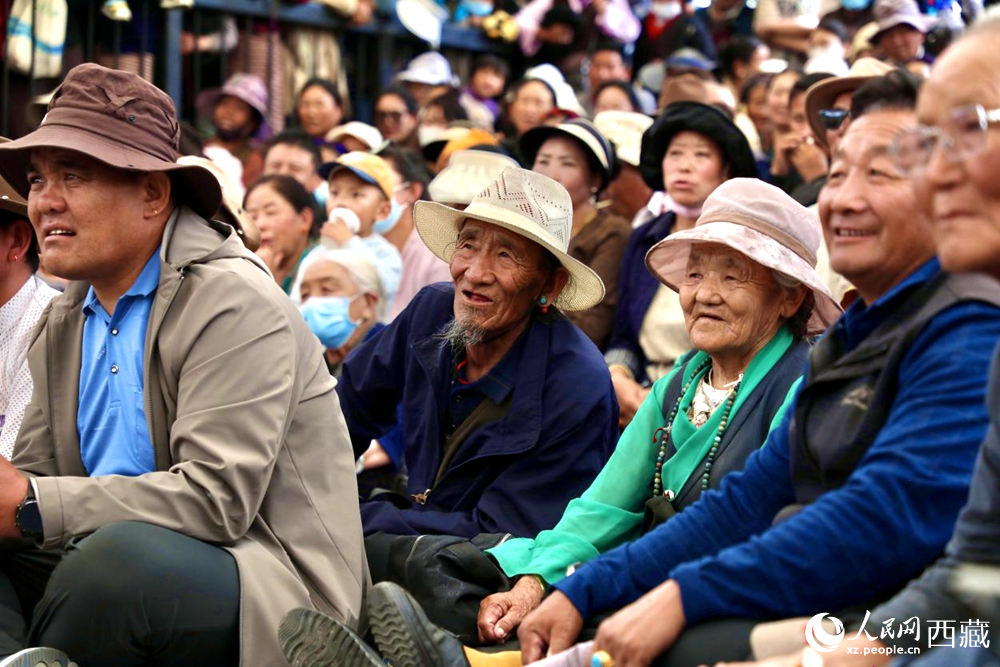 當(dāng)?shù)厝罕姾陀慰陀^看藏戲演出。