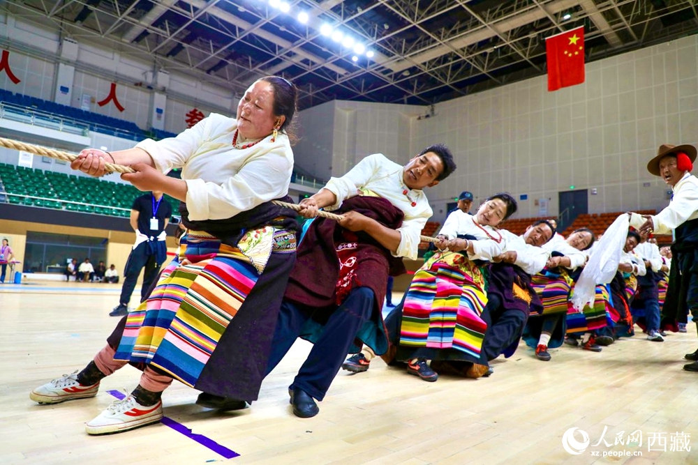身著民族服裝的農(nóng)牧民選手在拔河比賽現(xiàn)場。